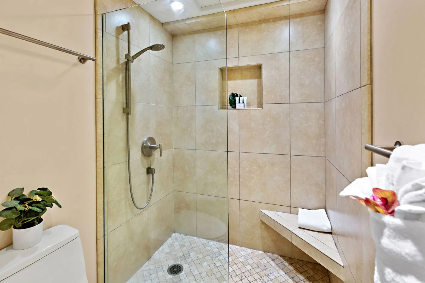 Glass-enclosed shower with bench seating.