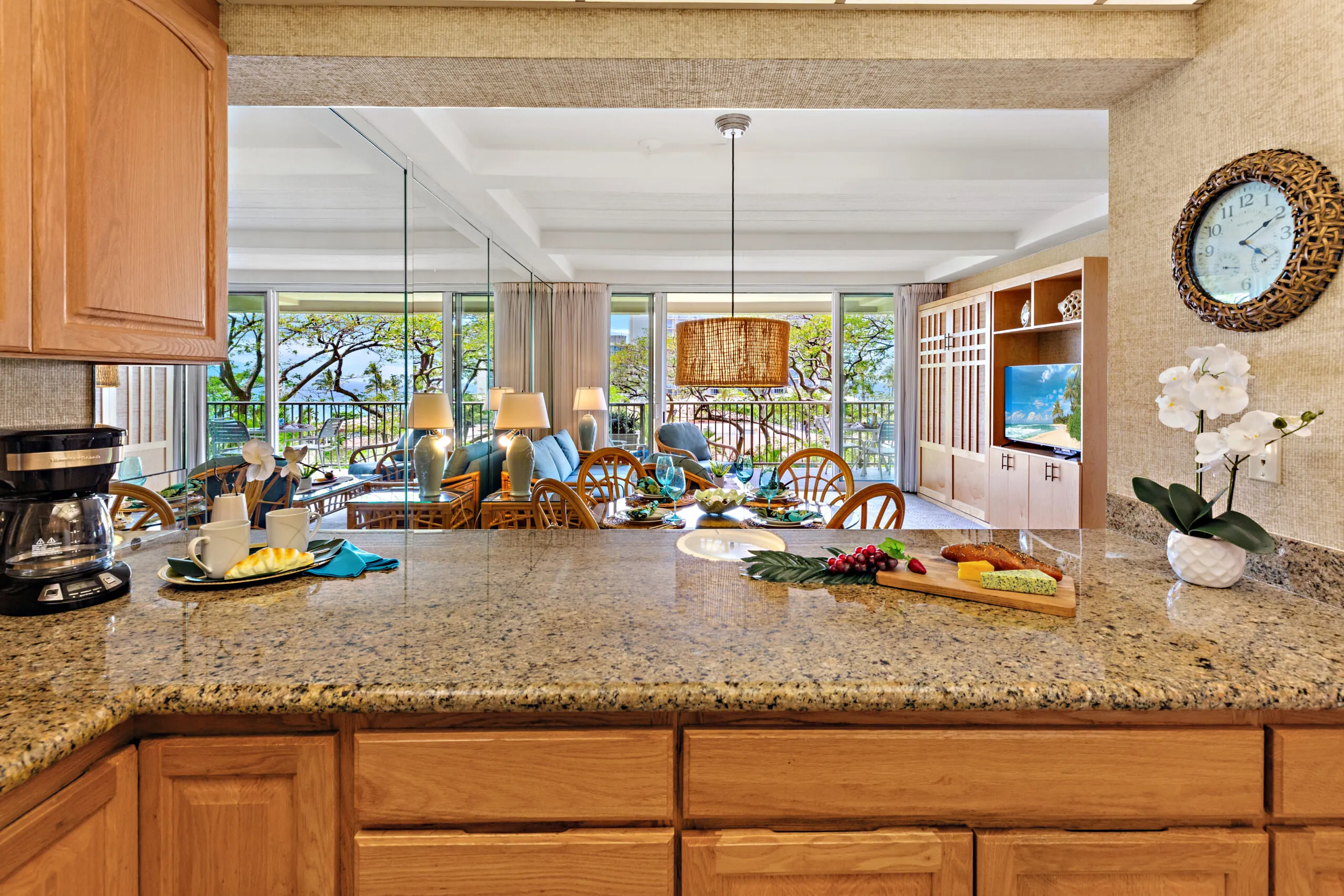 View from kitchen counter into a bright living area with dining table and seating.