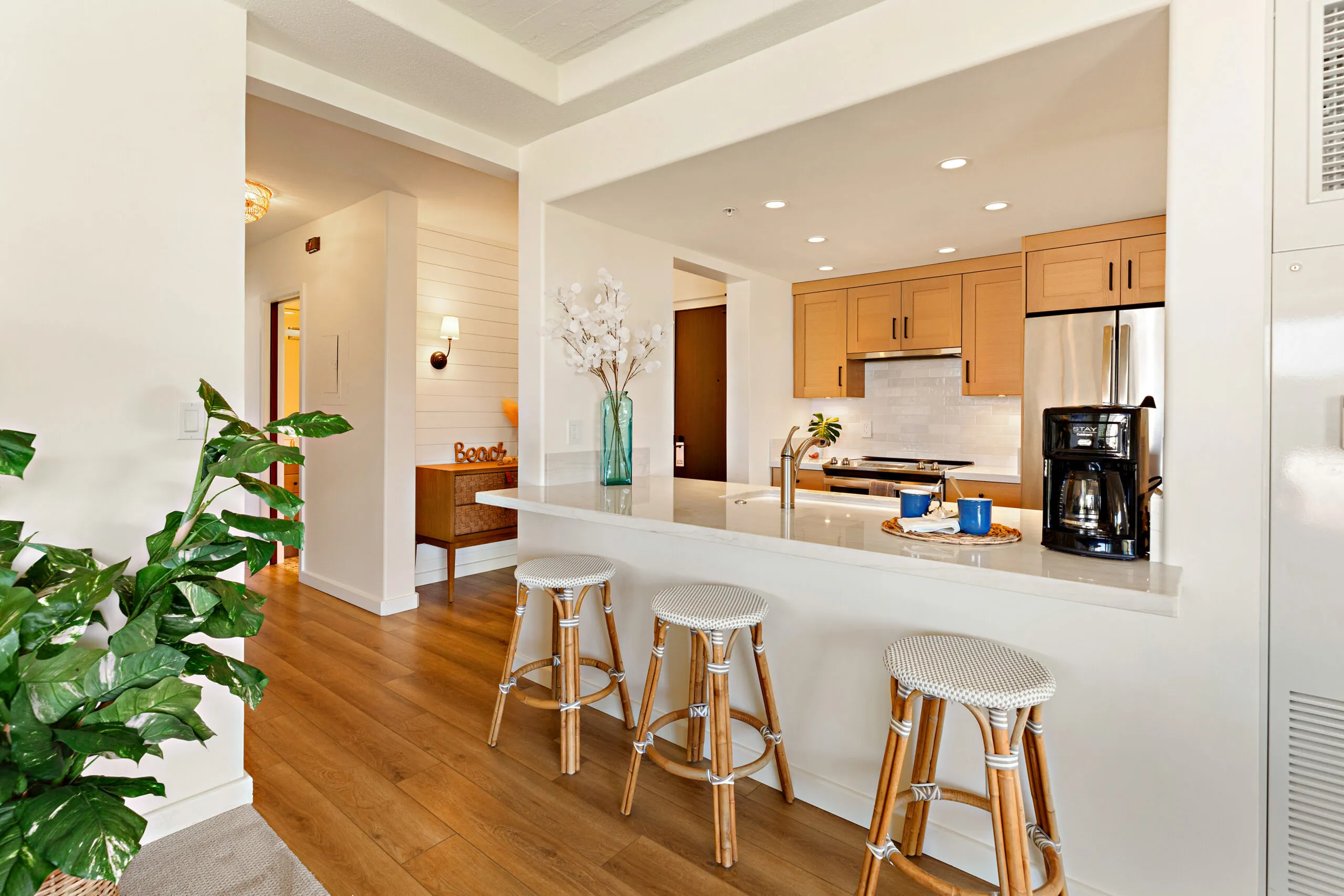 Open kitchen with a counter and barstools in a bright, modern space.