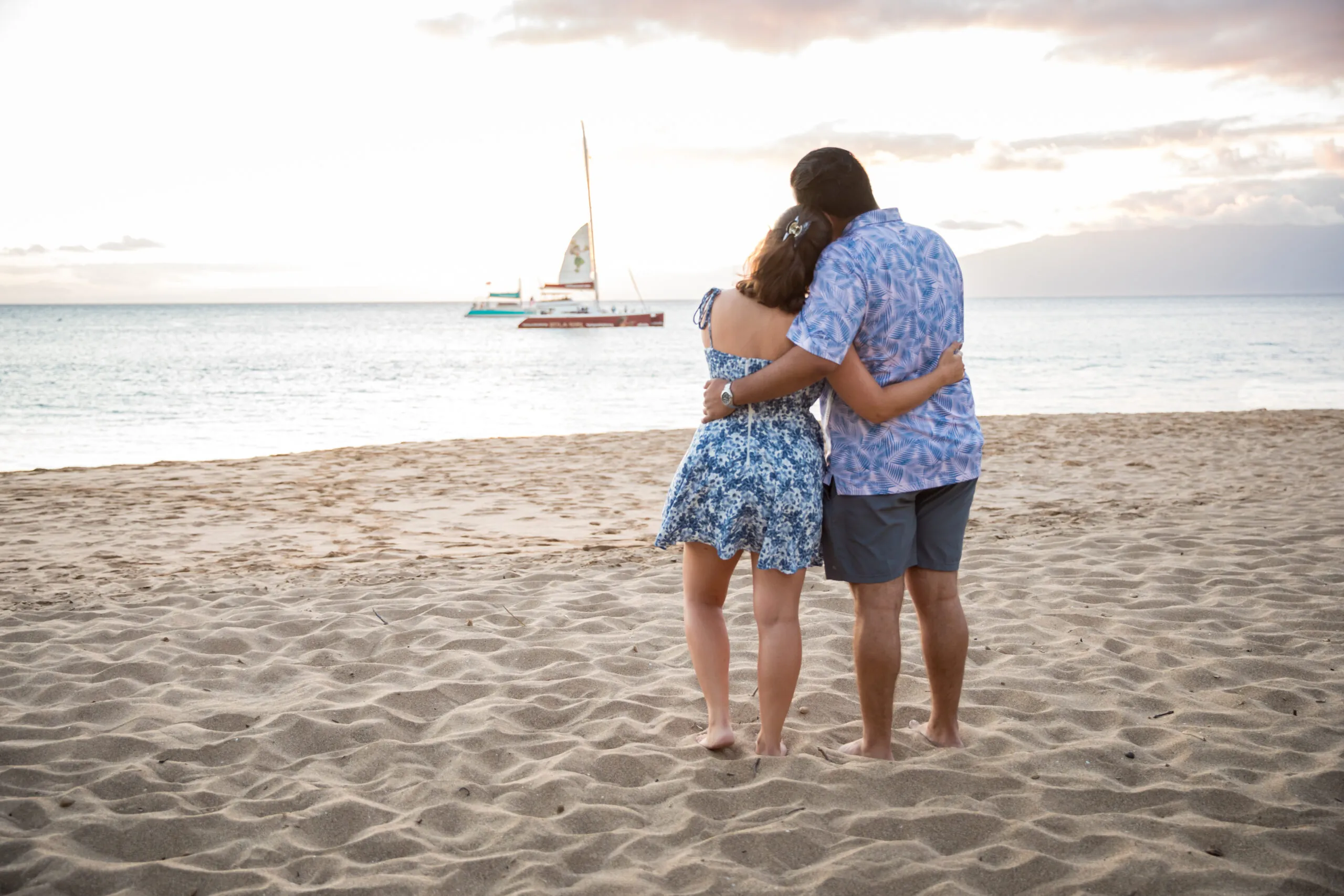 Couple embracing on the beach at sunset.